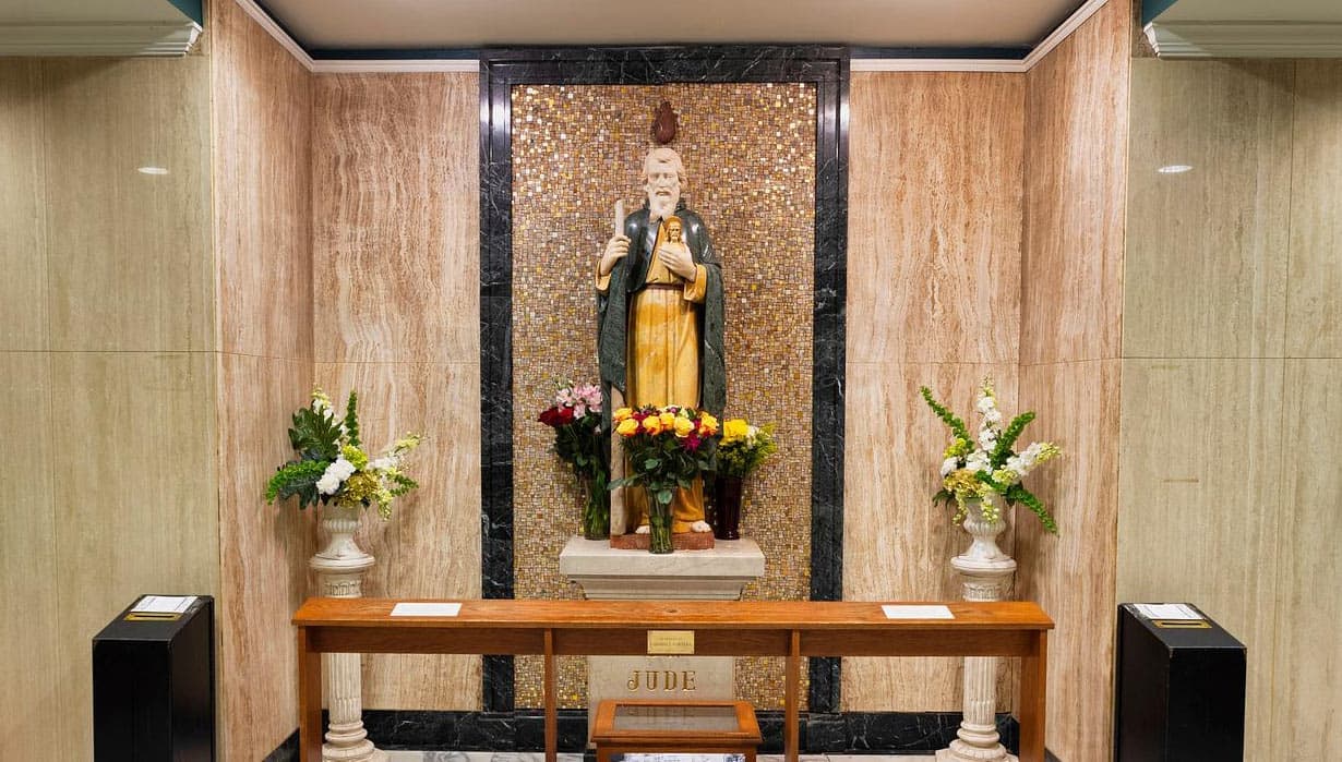 The shrine altar of St. Jude in Baltimore, the statue set against a gold mosaic niche and surrounded by flowers